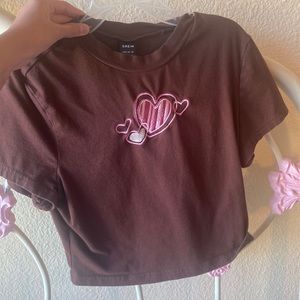 This shirt is so cute it’s a brown crop top with pink hearts fits amazing
